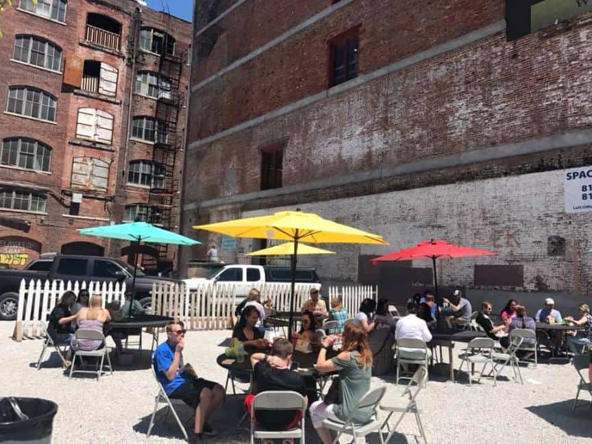 West Bottoms Historic District - several people sitting outside at patio tables enjoying snacks and shopping