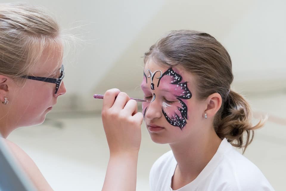 Kansas City fall festivals - woman face painting a young girl