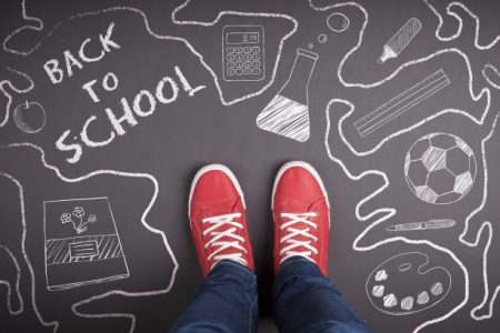 Back-to-school - red tennis shoes on a chalk drawing of school symbols