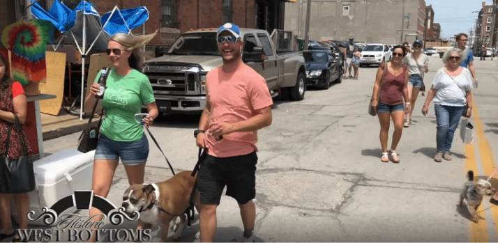 West Bottoms First Friday Festival - man and woman walking dogs outside among the shops