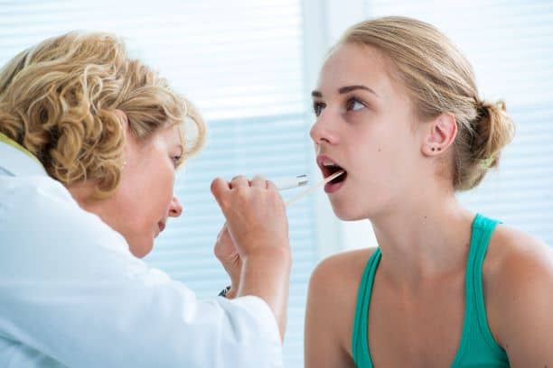 Youth sports physical - teenage girl being examined by doctor