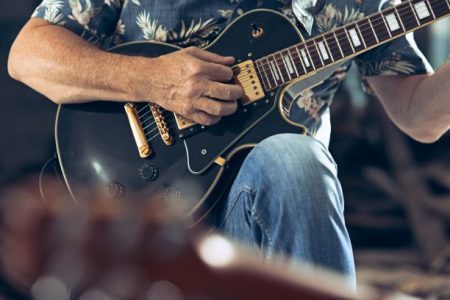 Knuckleheads Open Jam - man's finger strumming a guitar