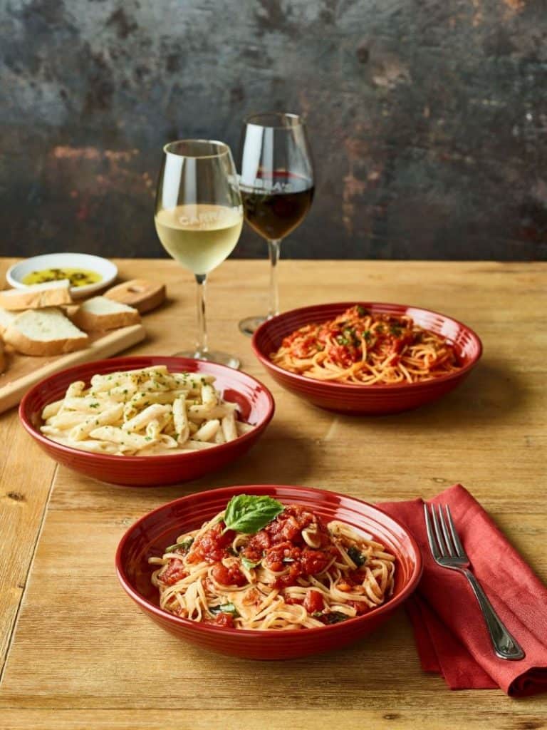 Kansas City restaurant deals - plates of pasta on a table with wine glasses