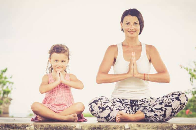 Family yoga at the Overland Park Arboretum - mom and young girl doing yoga outdoors