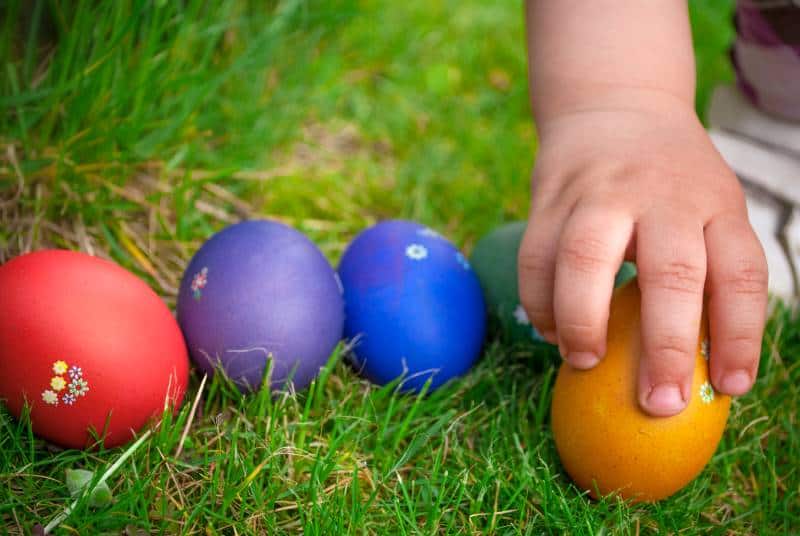 Easter Egg Hunts & Events in Kansas City - kid's hand picking up an Easter egg