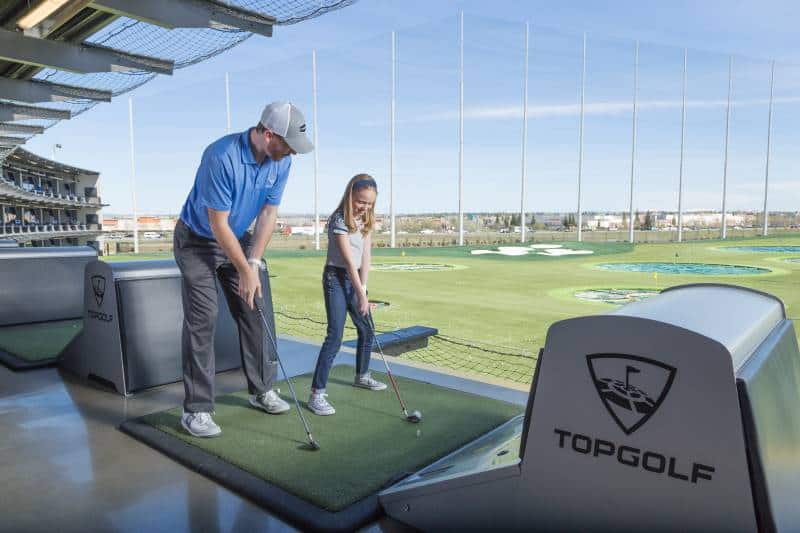 Weekly specials at Top Golf - dad and daughter playing golf