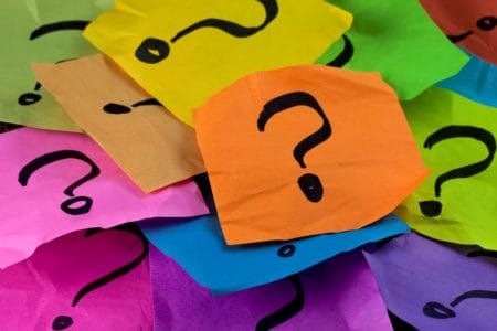 Neon Question Mark's layered on paper representing the Kansas City Free & Cheap Trivia Guide