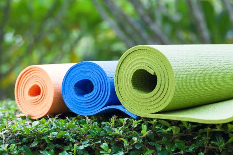 Rolled yoga mats on grass
