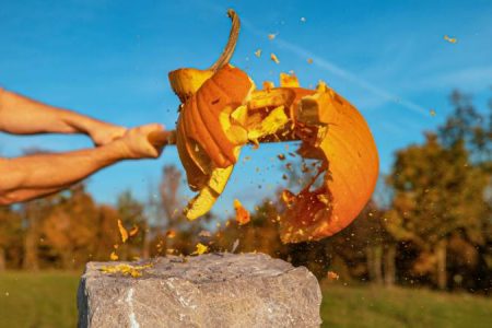 Halloween pumpkin smashed by baseball bat