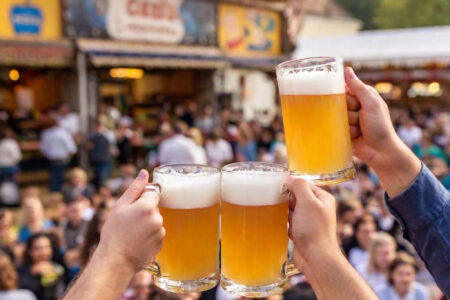 beers being held up in the air - deposit photos